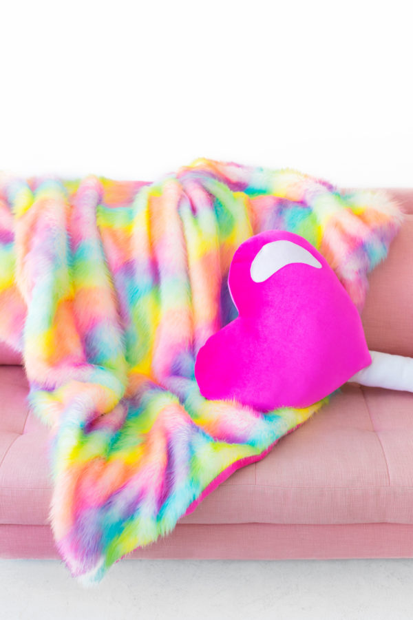 Pink heart pillow and rainbow fur blanket