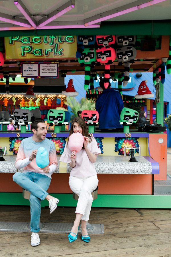 A man and a woman sitting and eating cotton candy