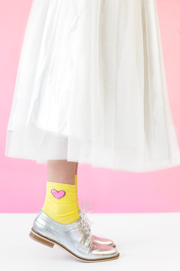 The end of a white dress and yellow socks