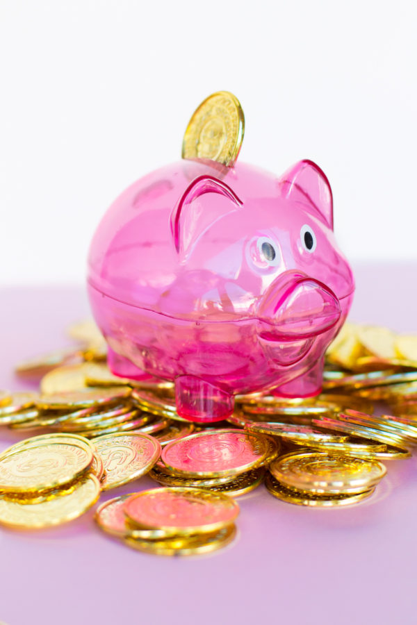 A pink piggy bank and fake gold coins