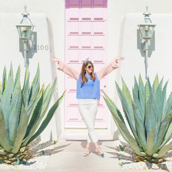 A woman standing in front of a pink door