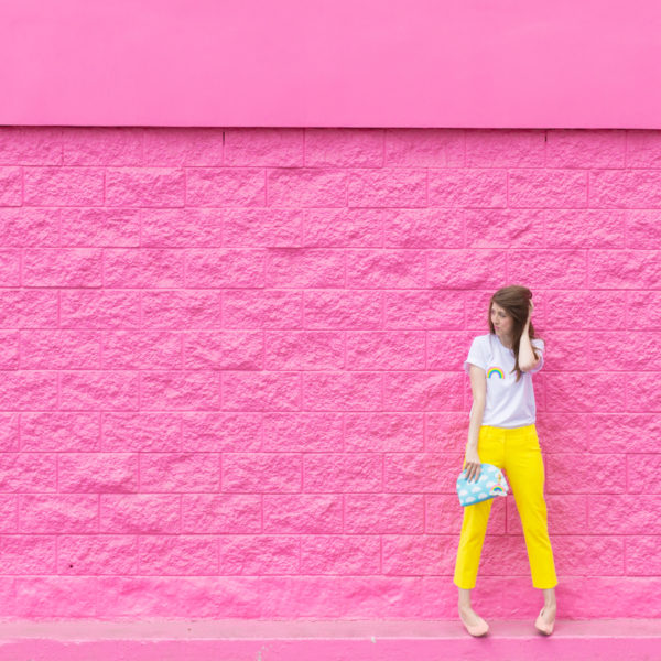 A girl standing in front of a pink wall