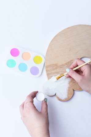 Someone painting a wood board white