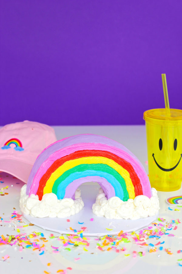 A rainbow cake and yellow cup