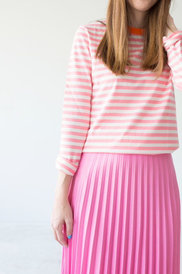 A girl in a pink shirt and pink skirt