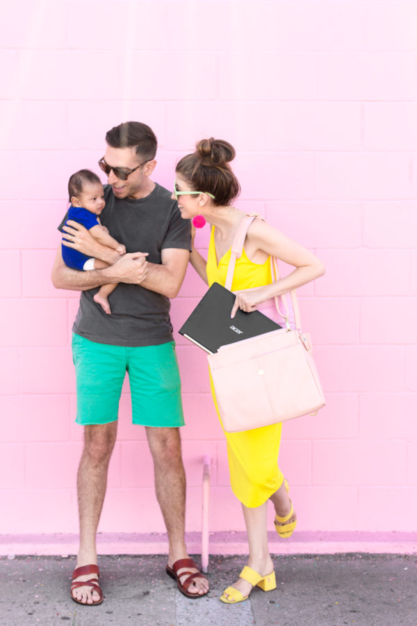 A family standing in front of a pink wall