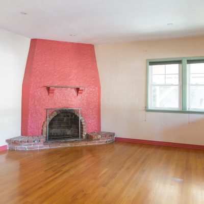 A large empty room with a pink fire place