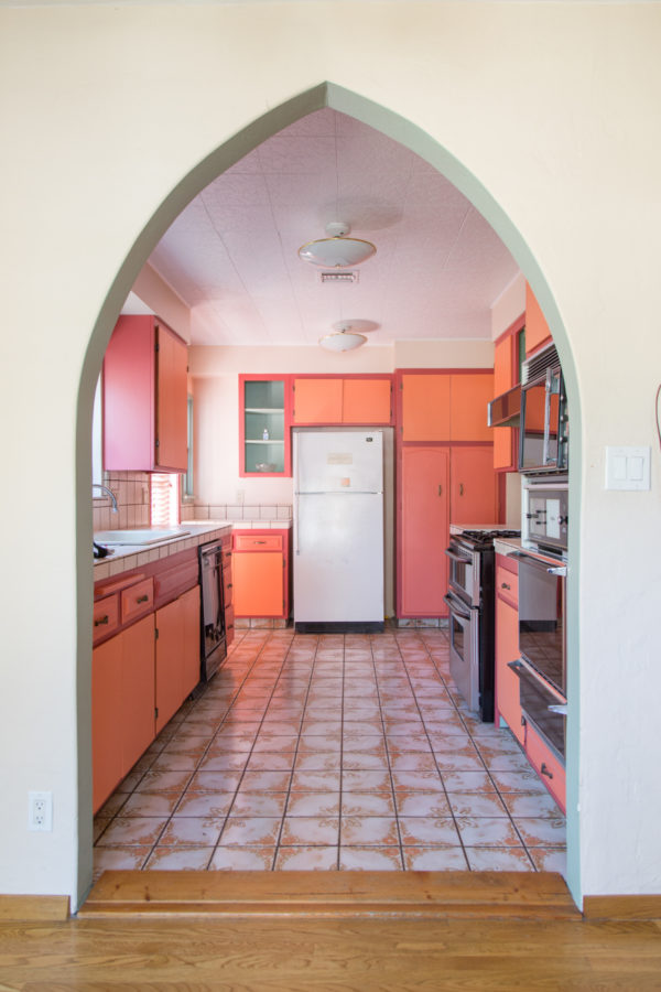A kitchen with a pink cabinets