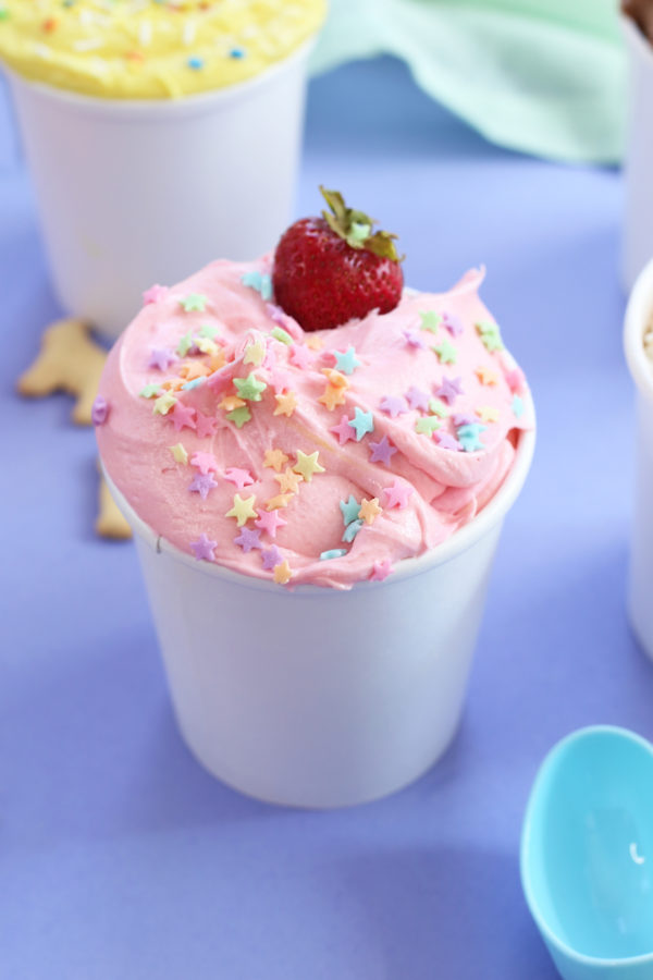 A cup with pink cream and a strawberry