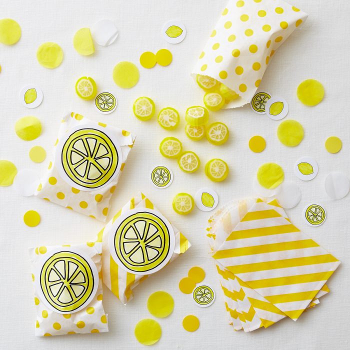 Overhead shot of lemon candies in yellow designed bags. 