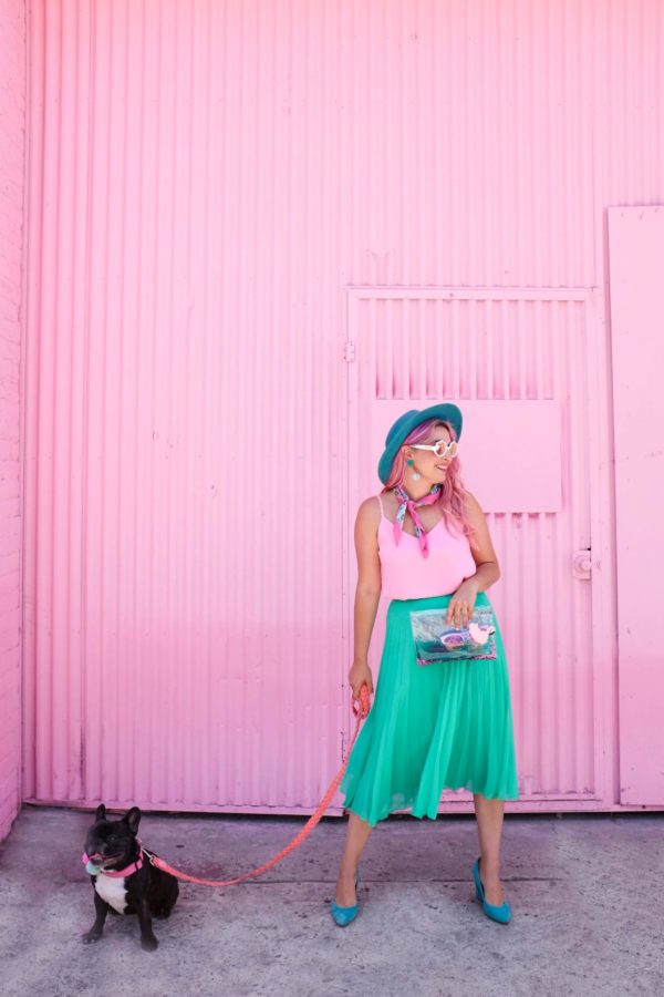 A person standing in front of a pink building