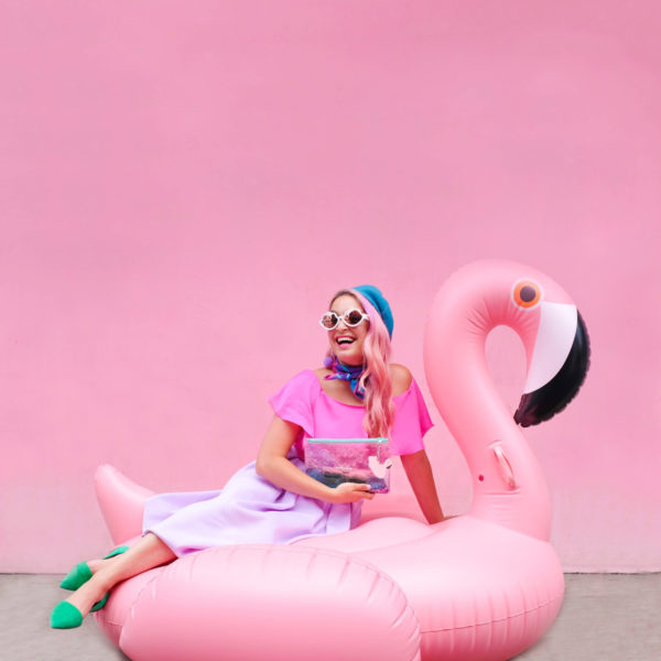 A woman sitting on a flamingo floatie 