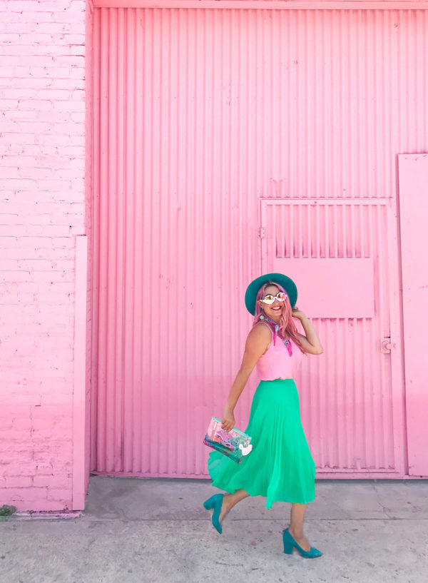 A girl in front of a pink building