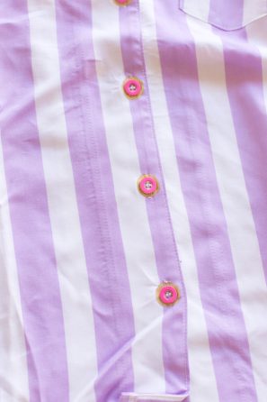 A close up of a purple and white striped shirt with donut buttons