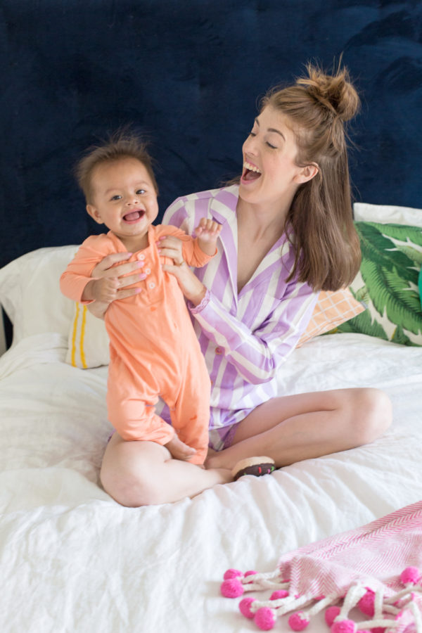 A woman and little boy sitting on a bed