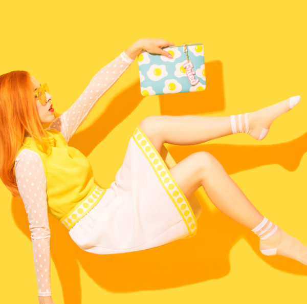 Someone holding an egg clutch in front of a yellow wall