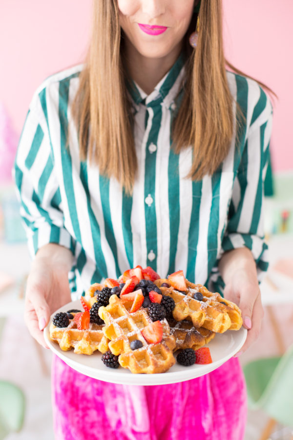 Someone holding a plate of waffles 