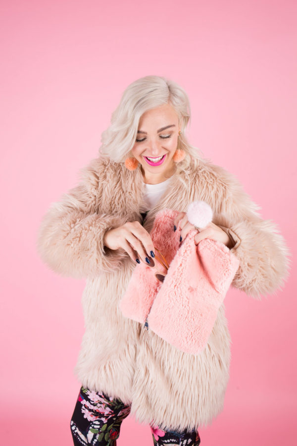 A woman with white hair holding a clutch