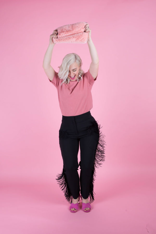 A woman in a pink shirt and black pants