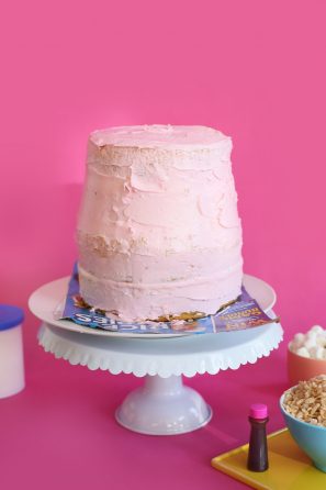 A pink cake sitting on top of a table