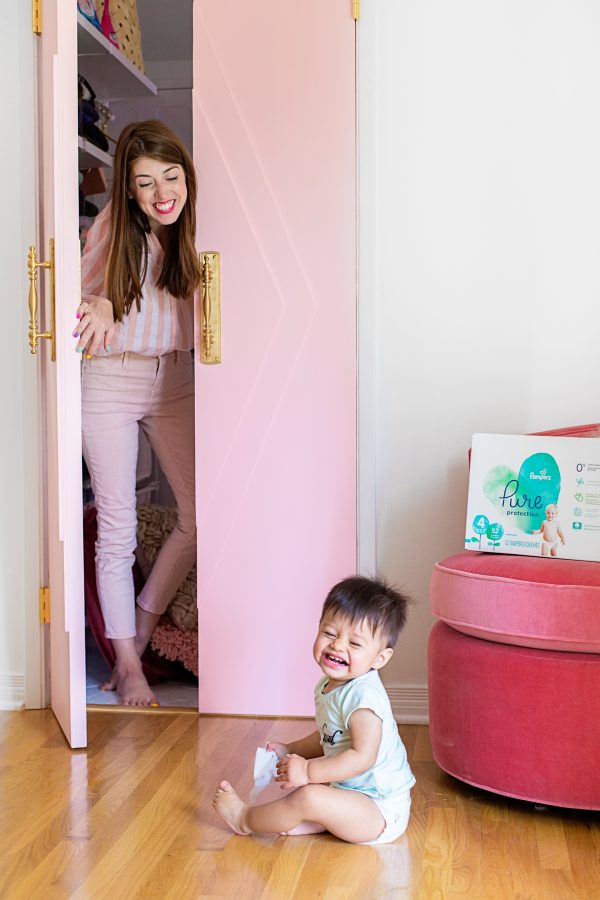 A woman opening a pink door