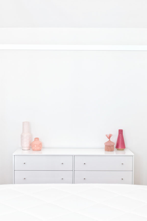 A white dresser with pink decor