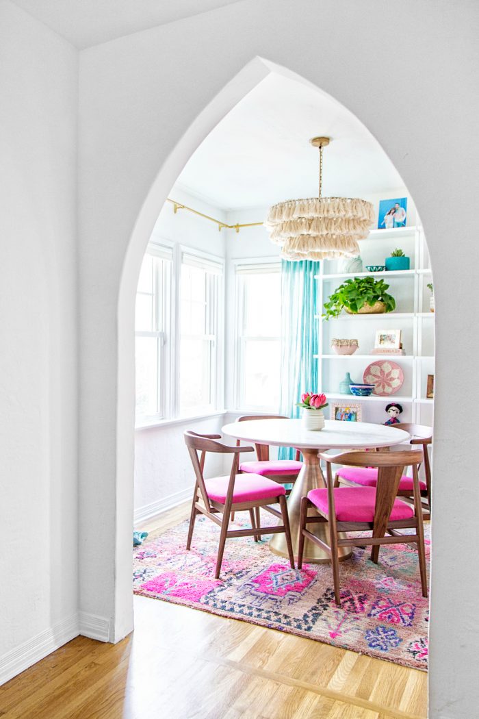 A dining room with pink chairs