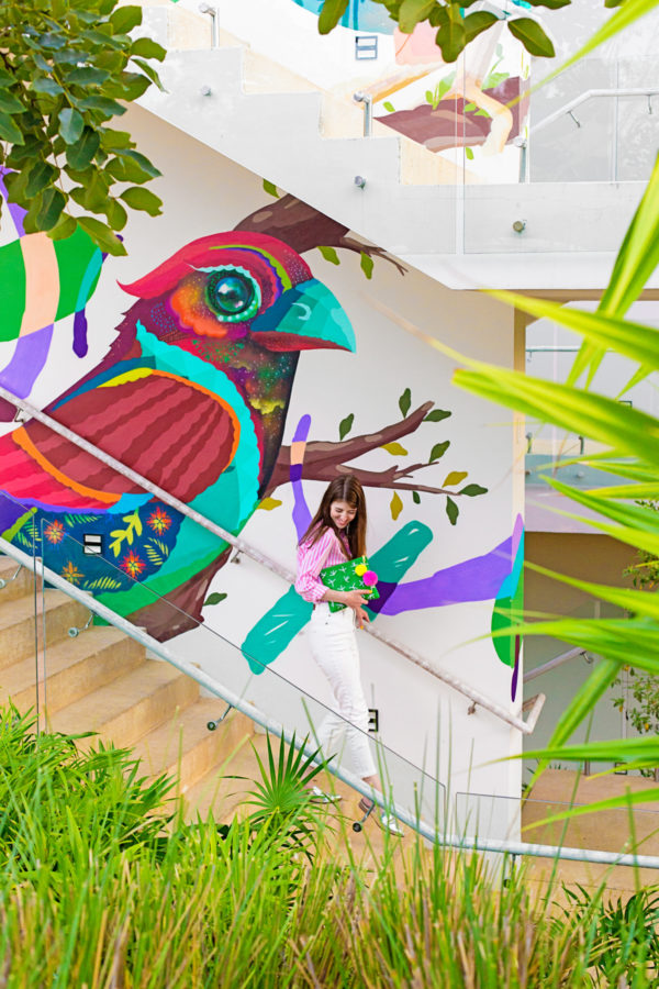 A woman in front of a colorful wall