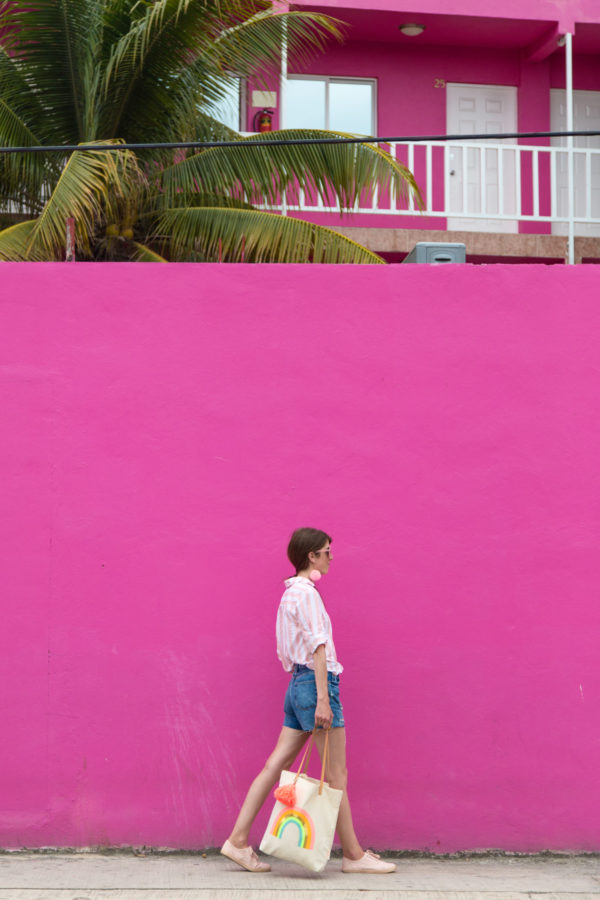 A person standing in front of a pink building