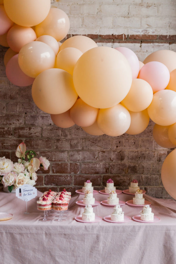 Yellows balloons over a table with cake