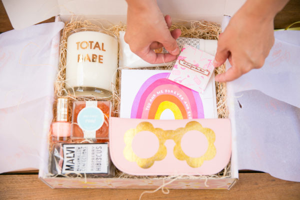 A box with a candle, gummies, and a pin