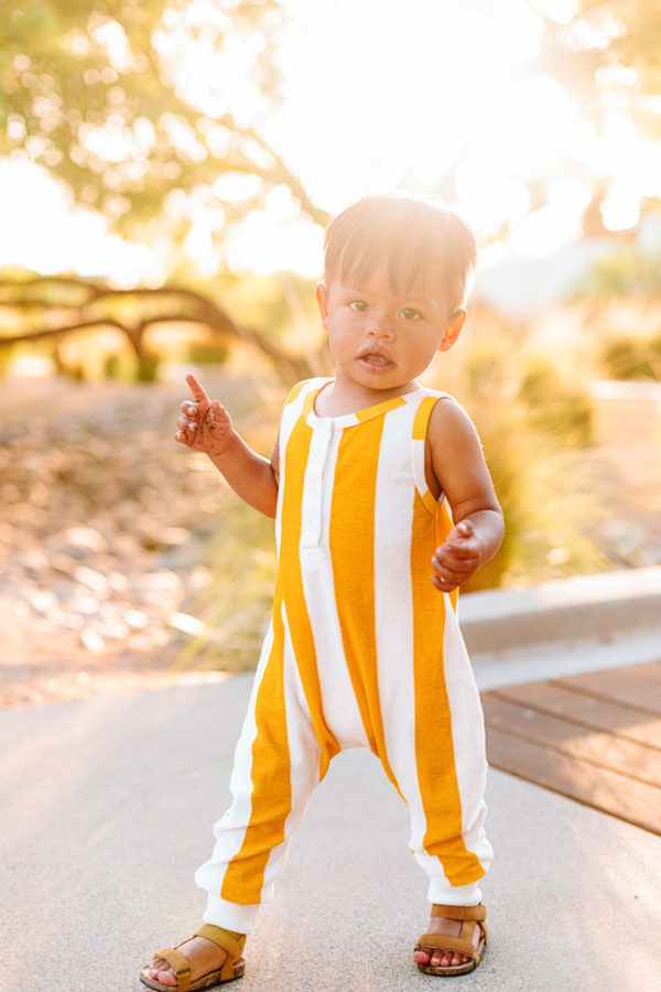 A little boy wearing a yellow jumpsuit 