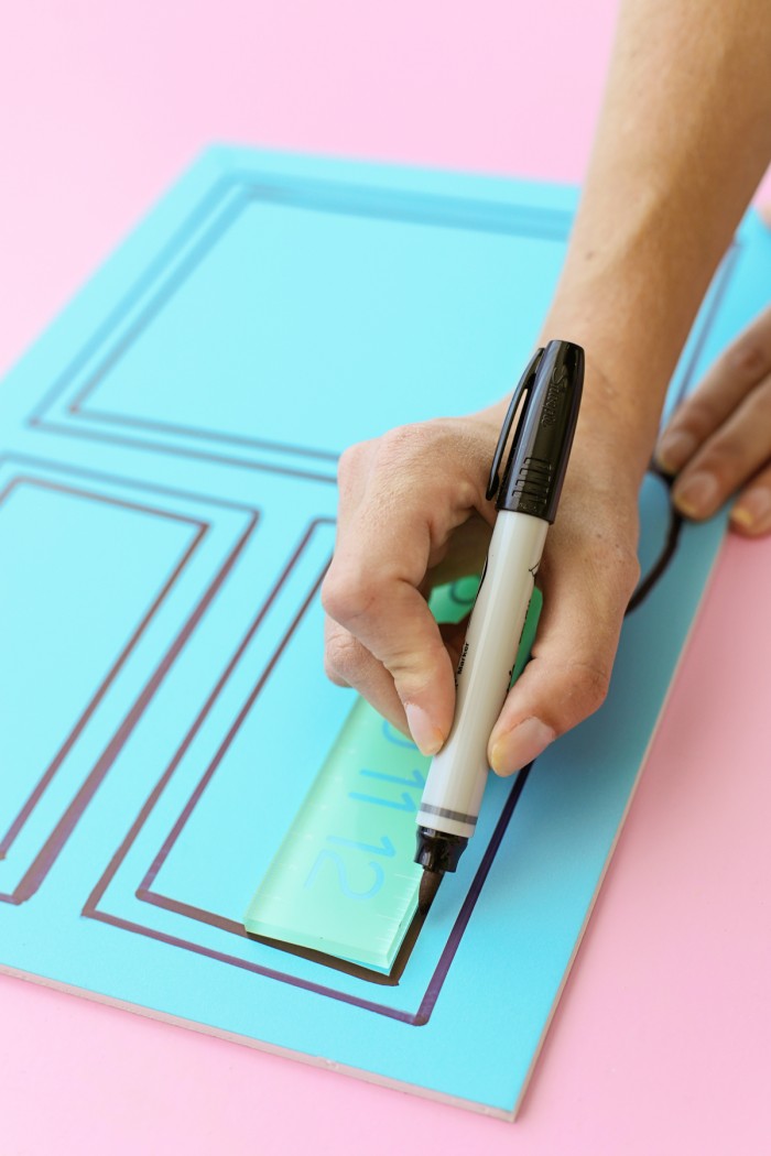 Drawing a line on a foam core door decoration with a black permanent marker