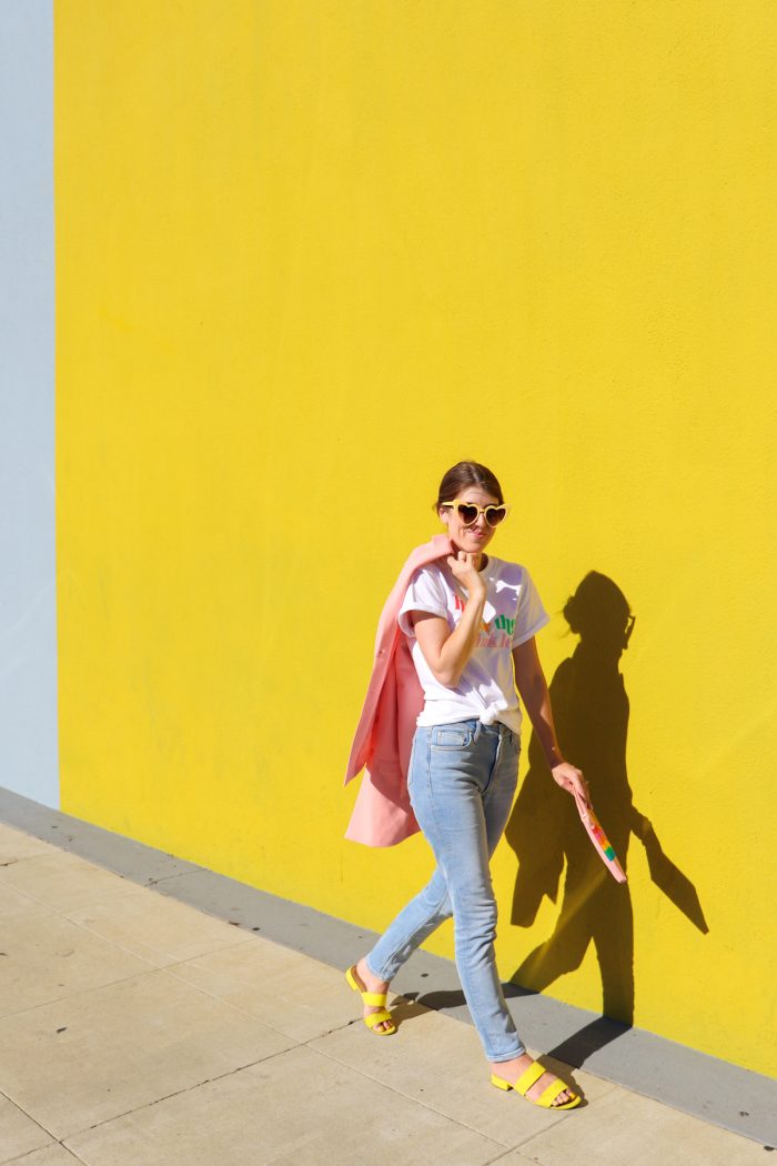 A person posing for a picture in front of a yellow wall