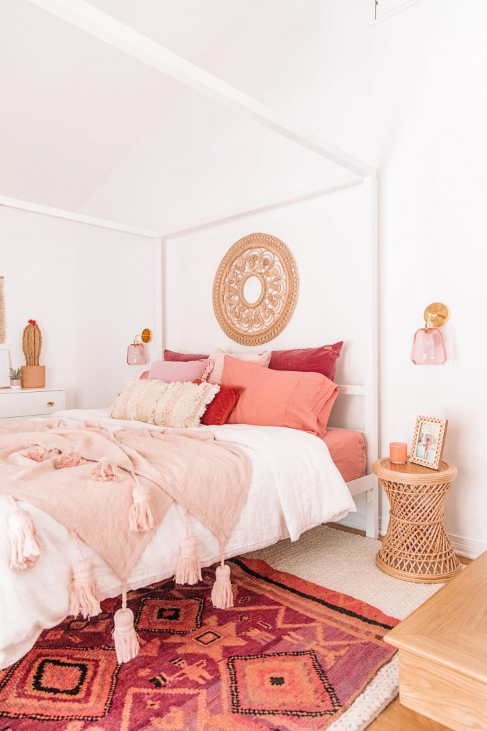 A bed with pink pillows and pink blankets