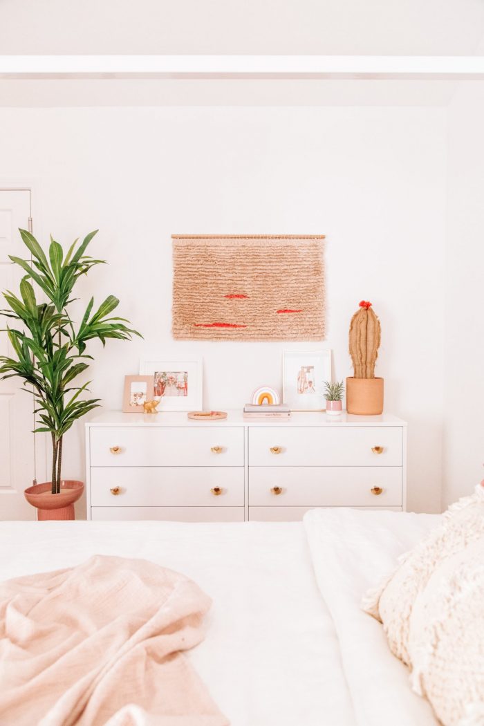 A bedroom with a white dresser