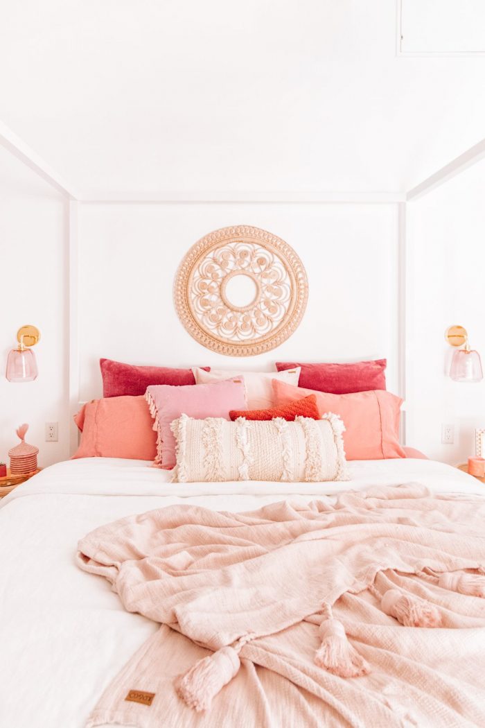 A bed with pink pillows