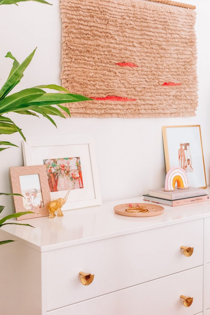 The top of a dresser with art and plants