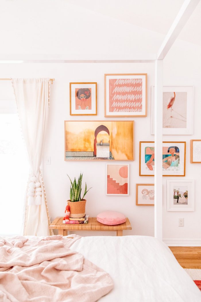 A bedroom with pink art