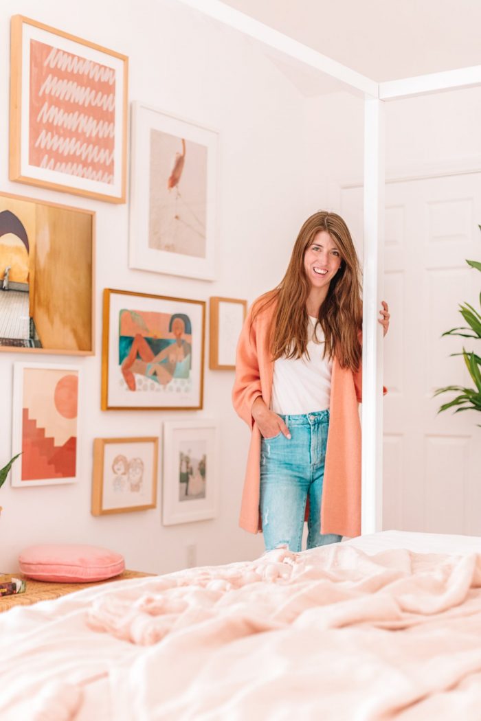 A woman standing next to a bed