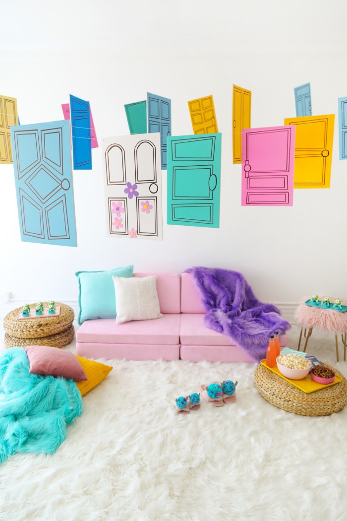 Pink couch with Monster's Inc inspired foam doors hanging above