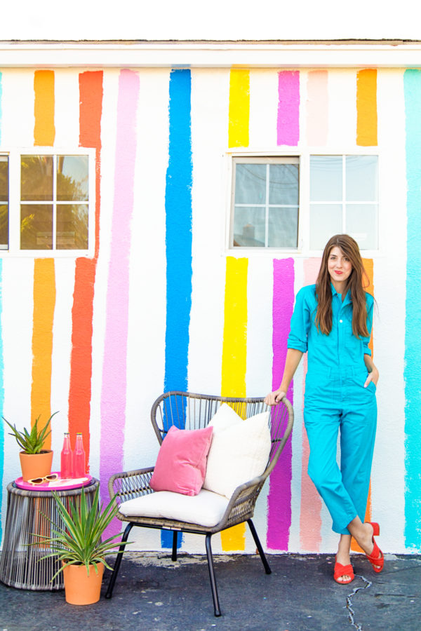 A woman standing in front of a rainbow building
