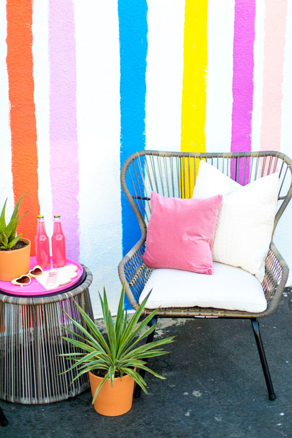 A chair and table in front of a rainbow wall