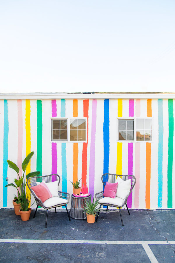 Two chairs in front of a rainbow wall