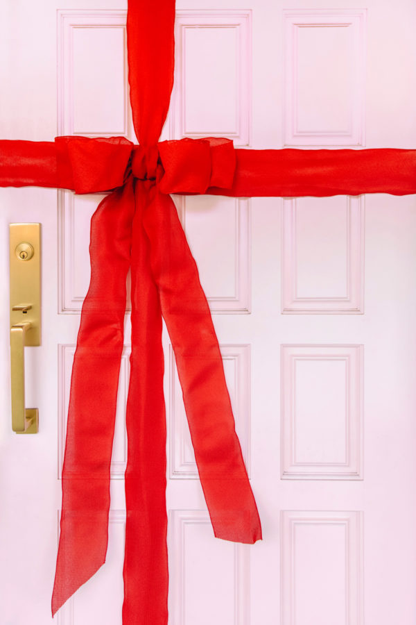 A pink door with a red ribbon