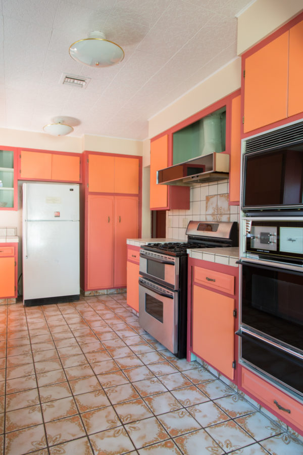 A kitchen with a stove and a refrigerator