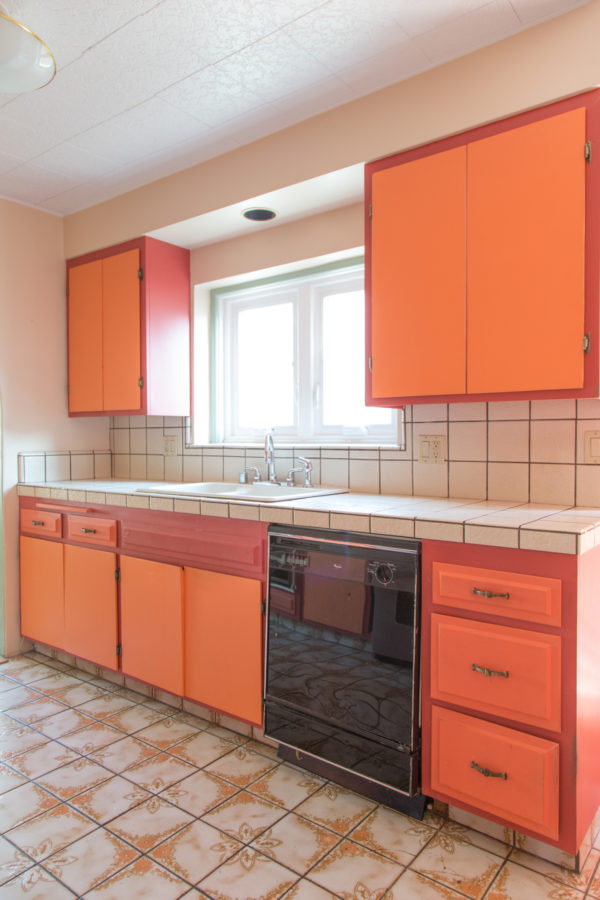 A kitchen with orange cabinets 