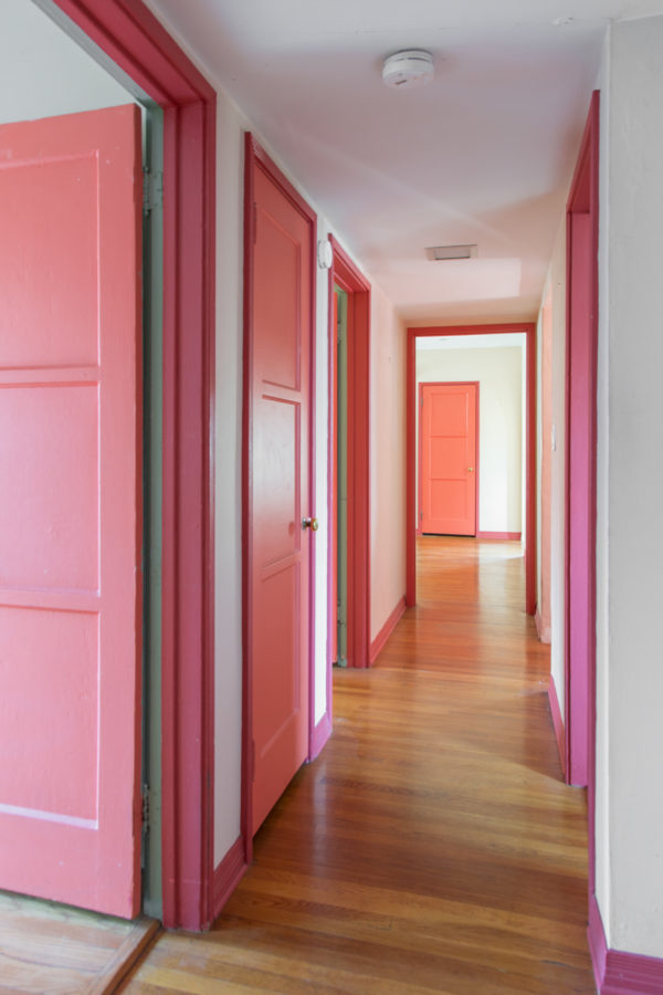 A hallway with pink doors
