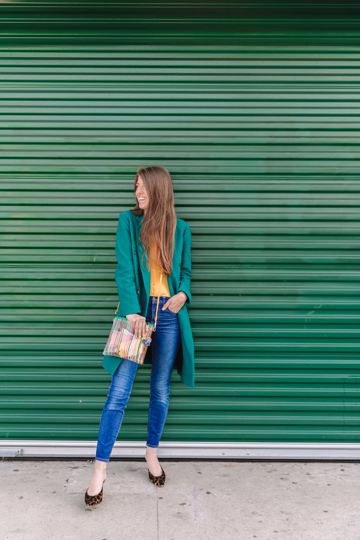 A woman standing in front of a green wall