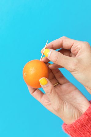 An orange with a stick in it